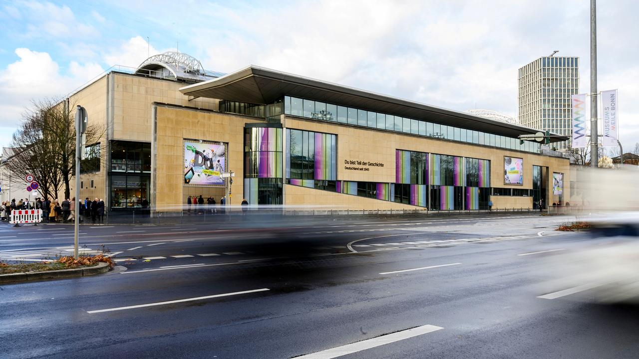 Das Haus der Geschichte Bonn: Ein gelbes Flachdachgebäude an einer befahrenen breiten Straße.