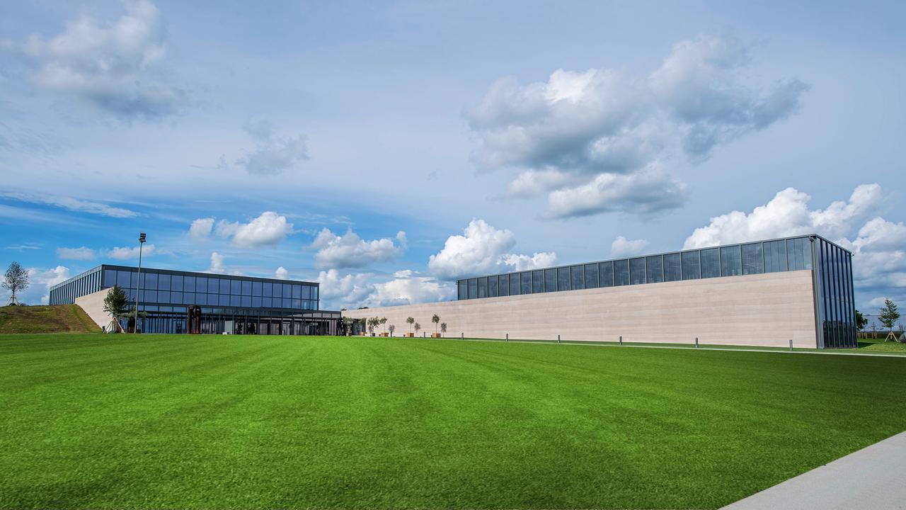 Zwei moderne Gebäude mit viel Glas auf grüner Wiese