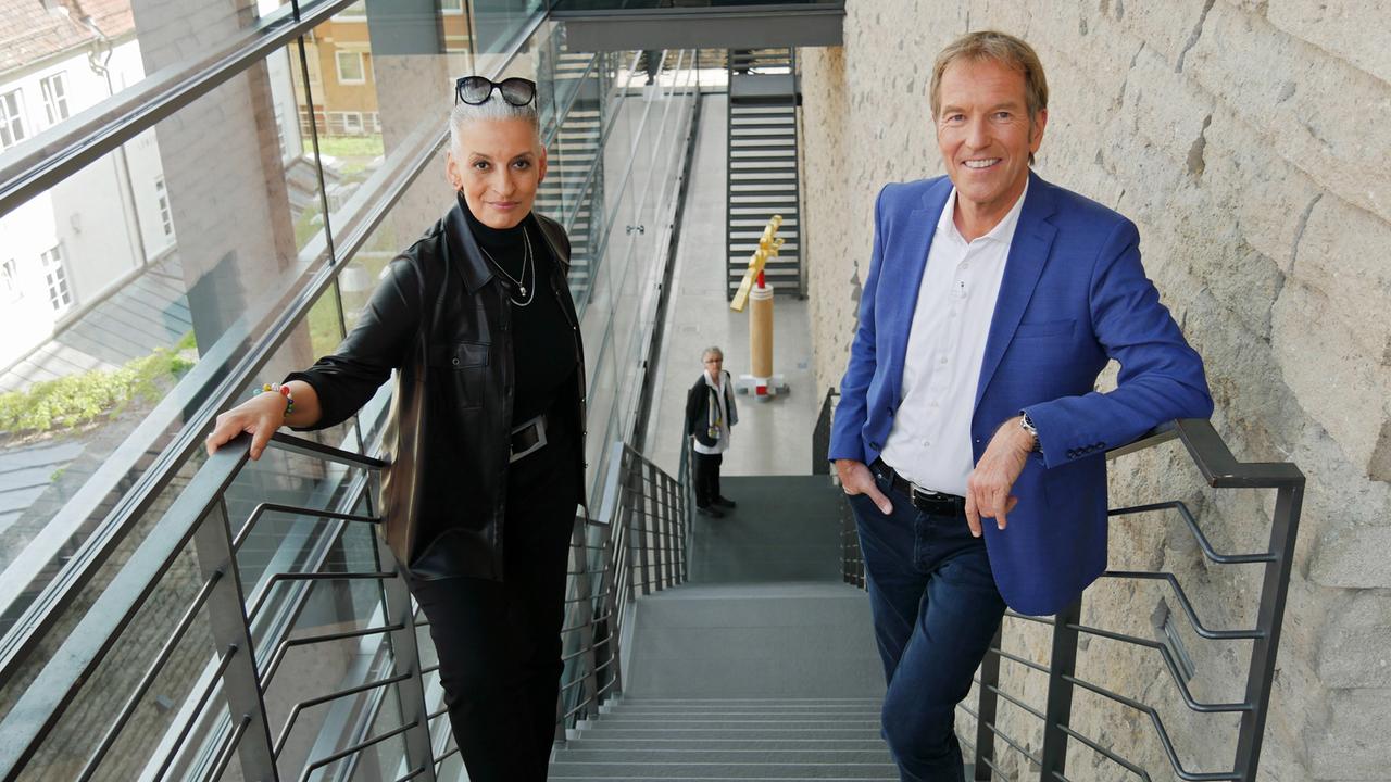 Ein Mann und eine Frau posieren auf der Treppe eines hohen Museums-Gebäudes