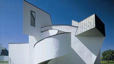 Ein weißes verschachteltes Gebäude vor blauem Himmel.