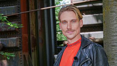 Porträt eines jungen Mannes in orangem T-Shirt