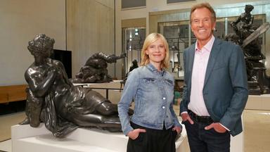 Eine blonde Frau und ein älterer Mann in einem Museum.