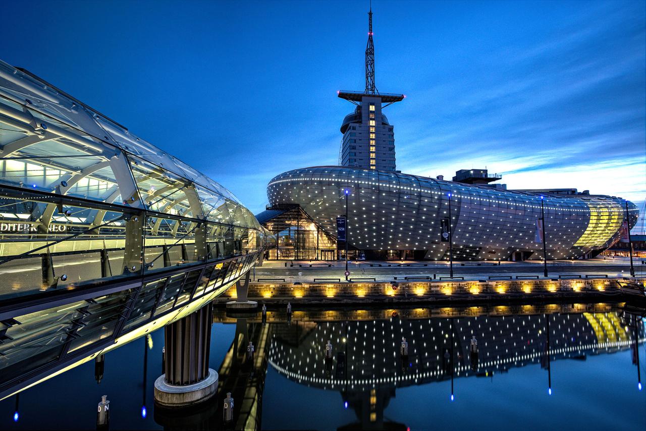 Modernes Gebäude am Abend spiegelt sich im Wasser