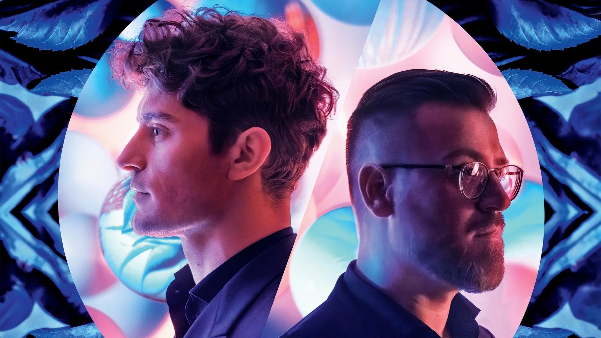 Man sieht zwei Männer, Hinterkopf an Hinterkopf, umgeben von bunten, futuristischen Formen.