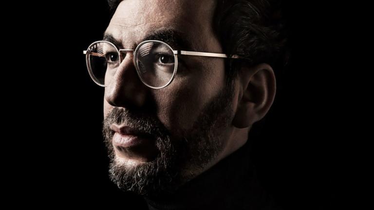 Man sieht das Gesicht eines Mannes mit Brille.