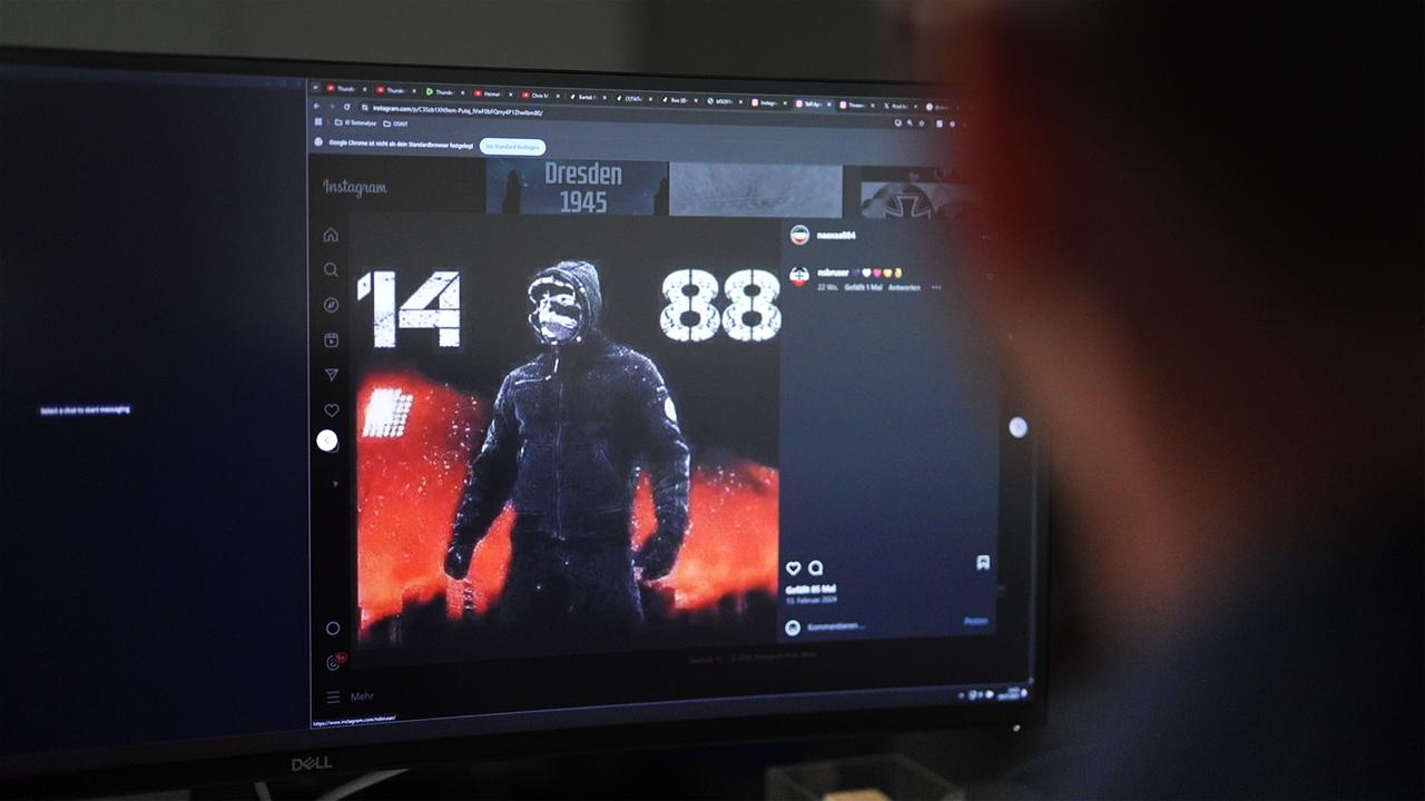 Bildschirm mit vermummter Person und rechtsextremen Zahlencodes. Die 88 steht für "Heil Hitler", die 14 für die vierzehn Worte: "We must secure the existence of our people and a future for white children“.