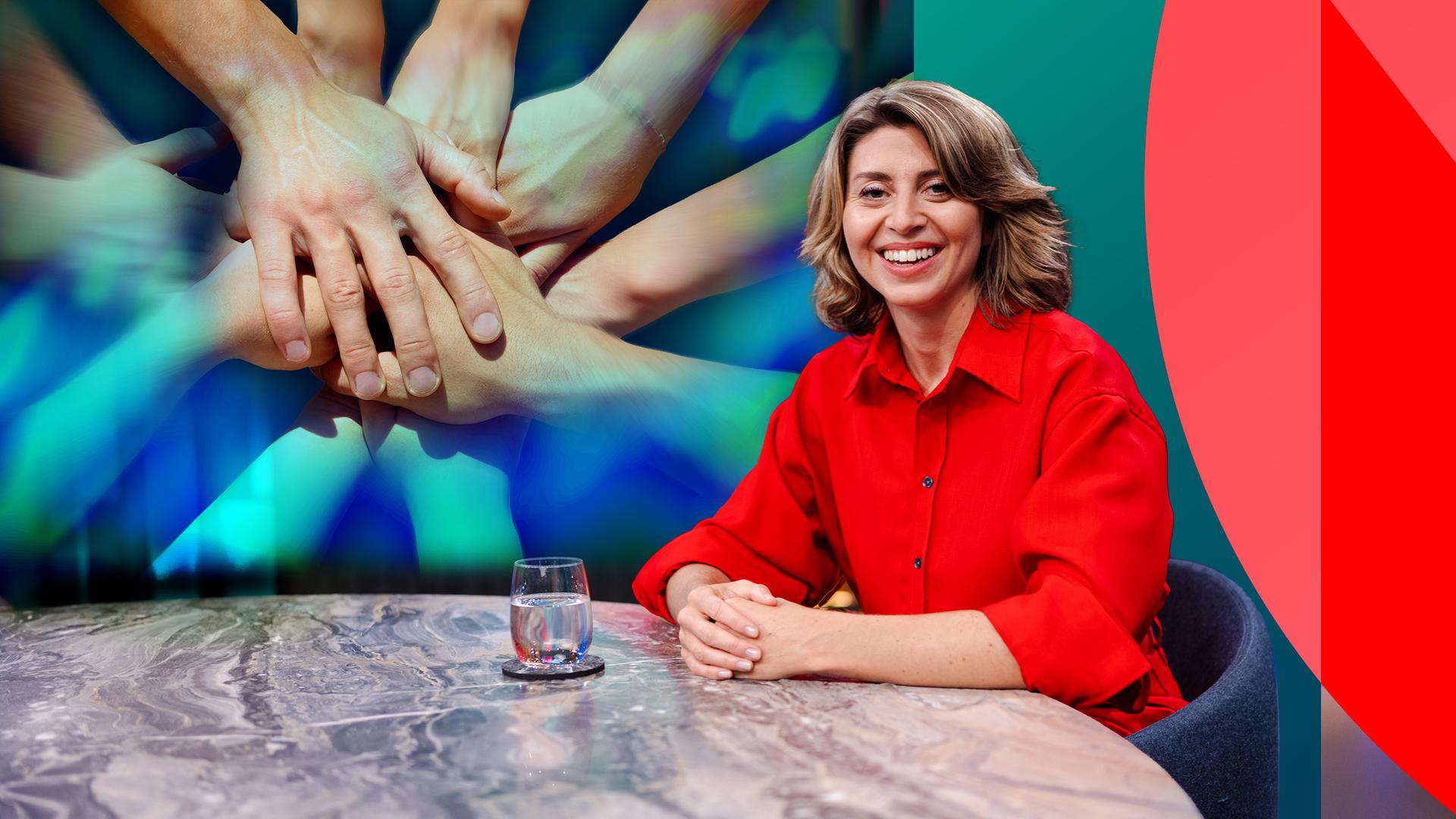die Moderatorin Stephanie Rohde im Studio an einem Tisch, im Hintergrund ein Foto mit sich umfassenden Händen