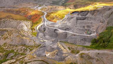 Luftbild eines Steinbruchs mit grauem Schutt in grüner Umgebung