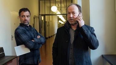 Joe Jessen (Ulrich Noethen) steht mit Ruiz (Jürgen Maurer) auf einem Flur und telefoniert.
