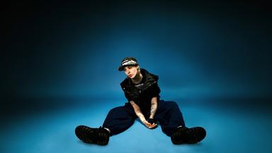 Ness auf dem Boden in einem blauen Studio