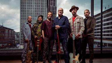 Die Nils Landgren Funk Unit im Stockholmer Kulturhuset, fotografiert von innen nach draußen, durch die Glasfassade mit Blick auf den Platz. 