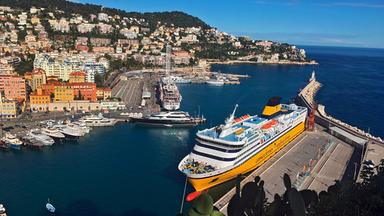 Der Hafen von Nizza mit einer Fähre im Vordergrund und der bebauten Steilküste im Hintergrund