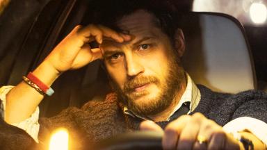 Ein Mann auf dem Fahrersitz eines Autos.