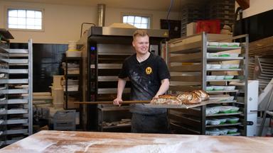 Bäckermeister Lukas Kröhl mit einem langen Teigheber in der Hand