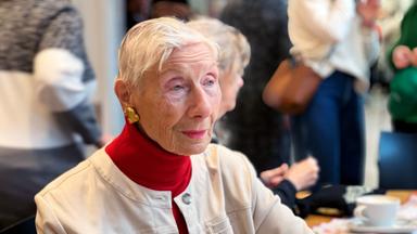 Eine ältere Dame an einem Tisch.