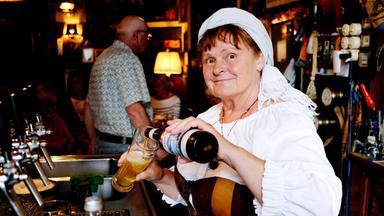 Eine Frau schenkt ein Bier in ein Glas.