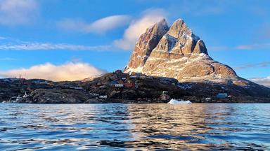Eine Stadt am Fuße eines einsamen Bergfelsens.
