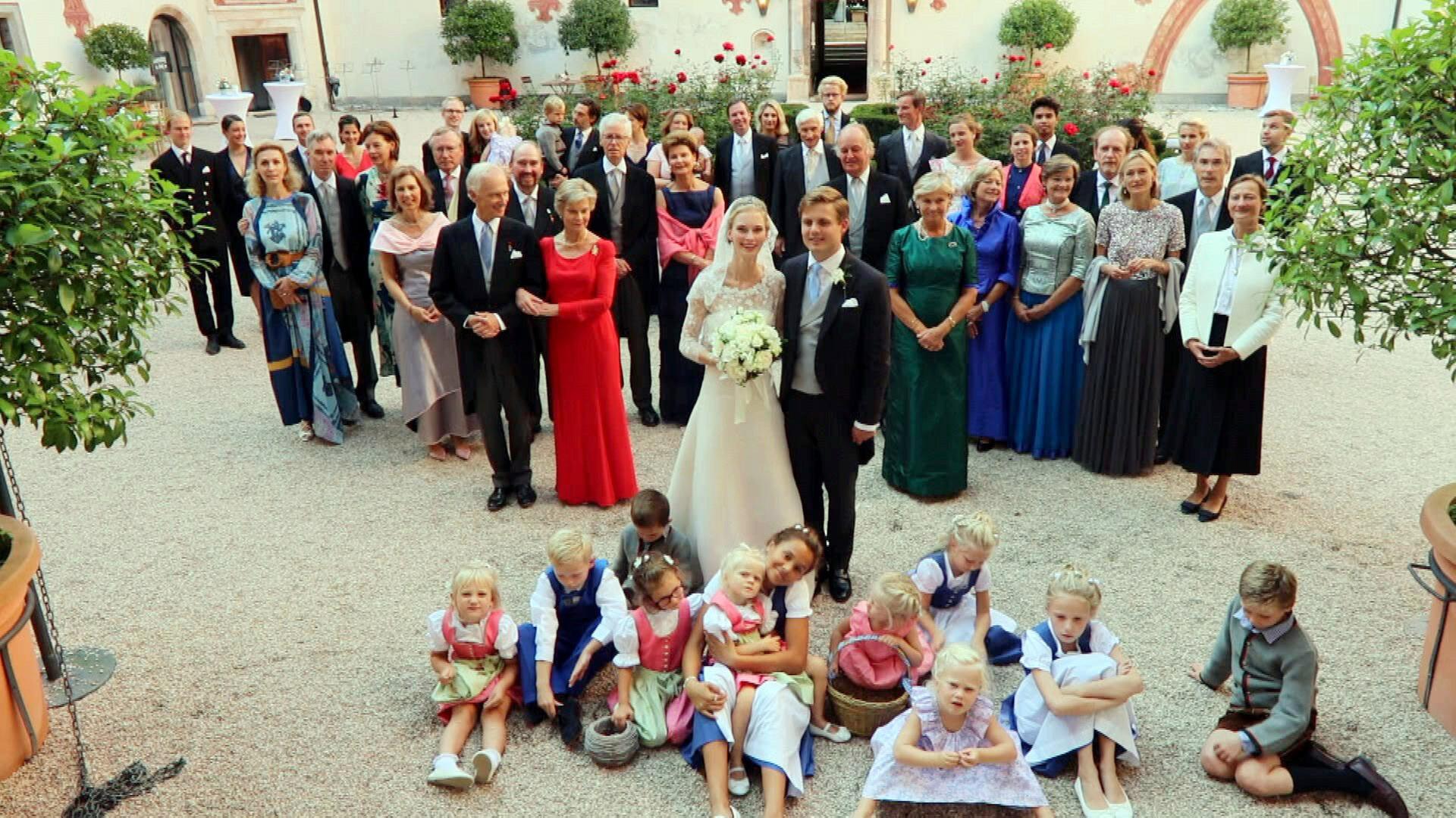Ein Gruppenbild mit festlich gekleideten Menschen und dem Brautpaar 