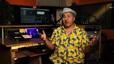 Nahaufnahme Lou Bega während eines Interviews in einem Studio. Der Hintergrund ist nur verschwommen sichtbar.