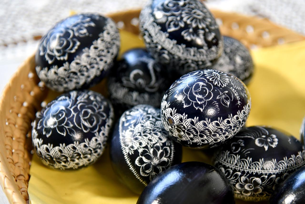 Schwarze, durch Kratztechnik verzierte Ostereier in einem Korb.