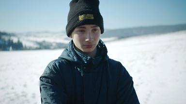 Junge mit Mütze und Anorak im Schnee