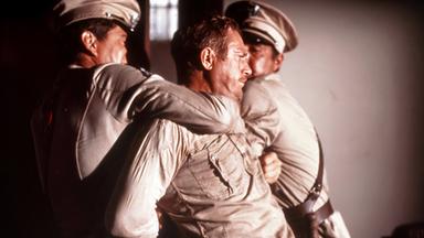 Ein Mann wird von zwei weiteren Männern überwältigt.