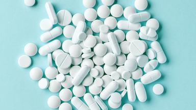 Diverse weiße Tabletten auf blauem Hintergrund