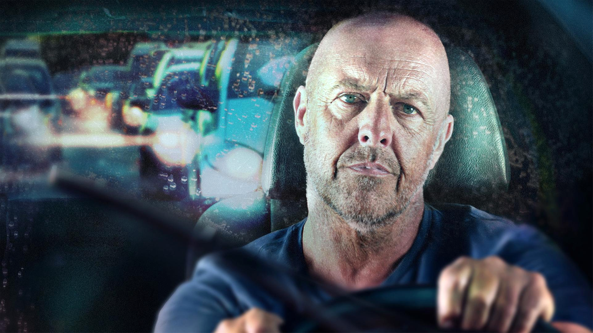 Blick durch regennasse Windschutzscheibe auf genervt wirkenden Fahrer.