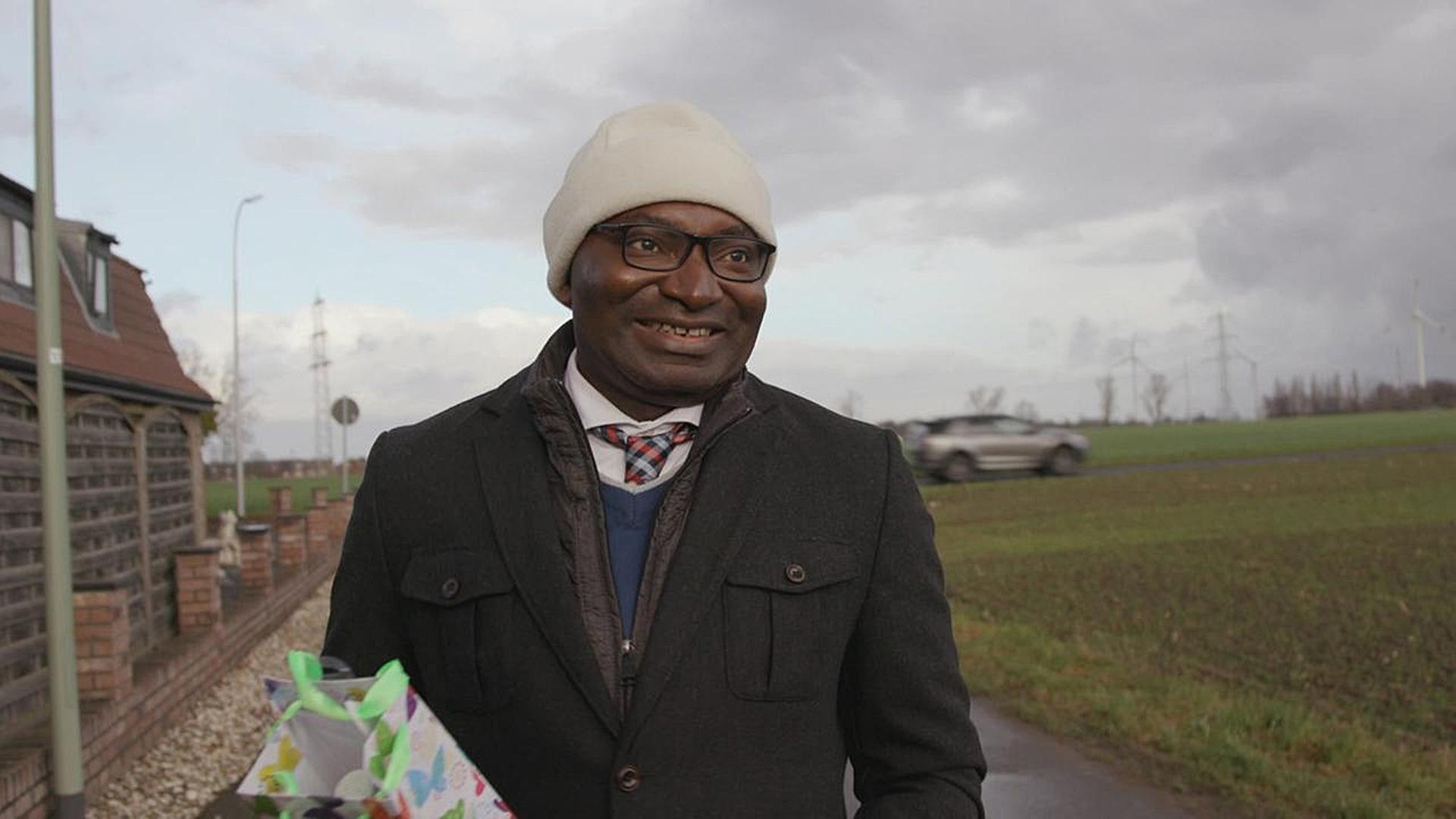 Pfarrer Uchenna Aba lacht in die Kamera.