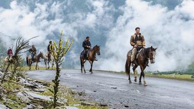 Männer auf Pferden.