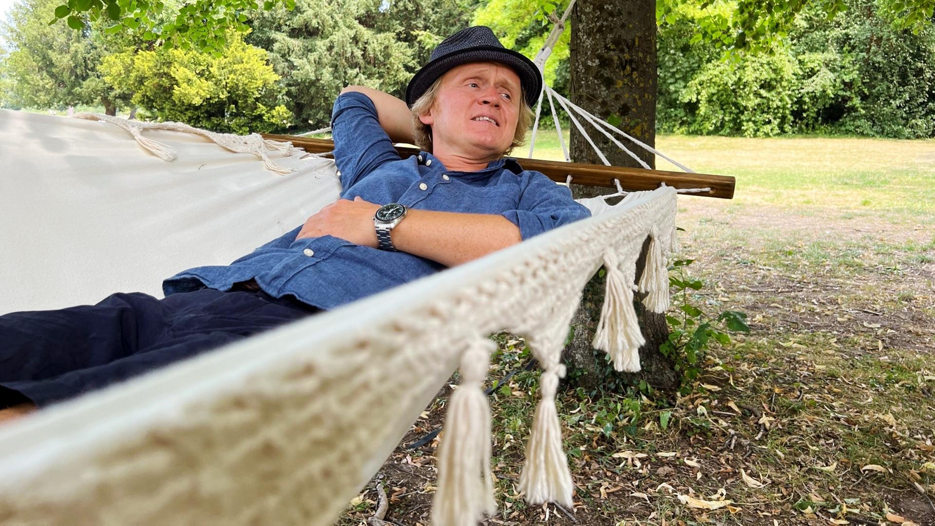 Pierre M. Krause liegt in der Hängematte