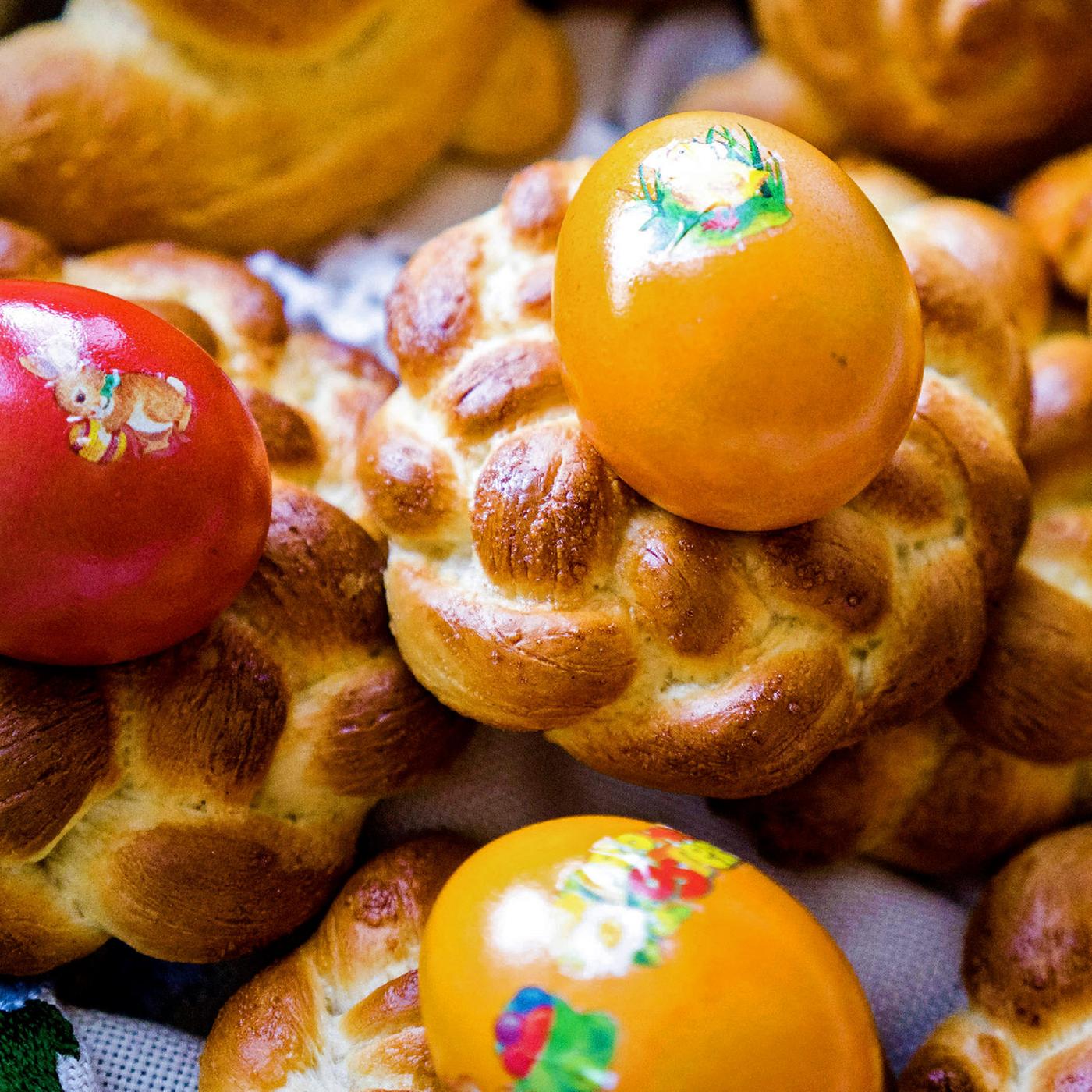 Mehrere kleine Osterkränze und bunte Eier.
