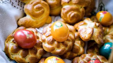 Mehrere kleine Osterkränze und bunte Eier.