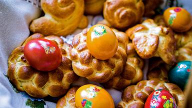 Mehrere kleine Osterkränze und bunte Eier.