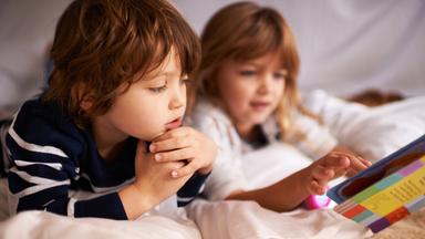 ein Junge und ein Mädchen lesen in einem Buch