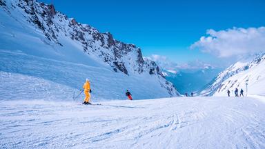 SkifahrerInnen auf einer Piste