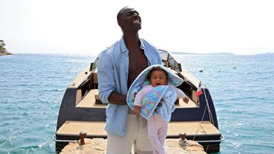 Ein Mann hält ein Baby auf dem Arm.