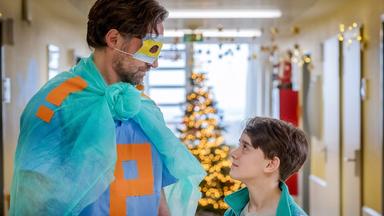 Tom Pohlmann (Benjamin Sadler) steht mit gebastelter Maske und Umhang vor Paul (Oskar Netzel)