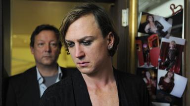 Kriminalhauptkommissar Hanns von Meuffels (Matthias Brandt) steht hinter Almandine Winter (Lars Eidinger) in der Garderobe. 