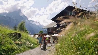 Kinder vor Bauernhaus in den Bergen