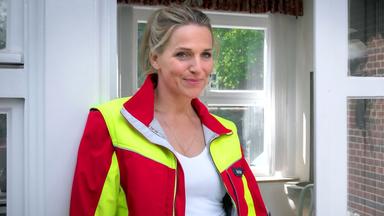 Eine blonde Frau in Sanitätskleidung.