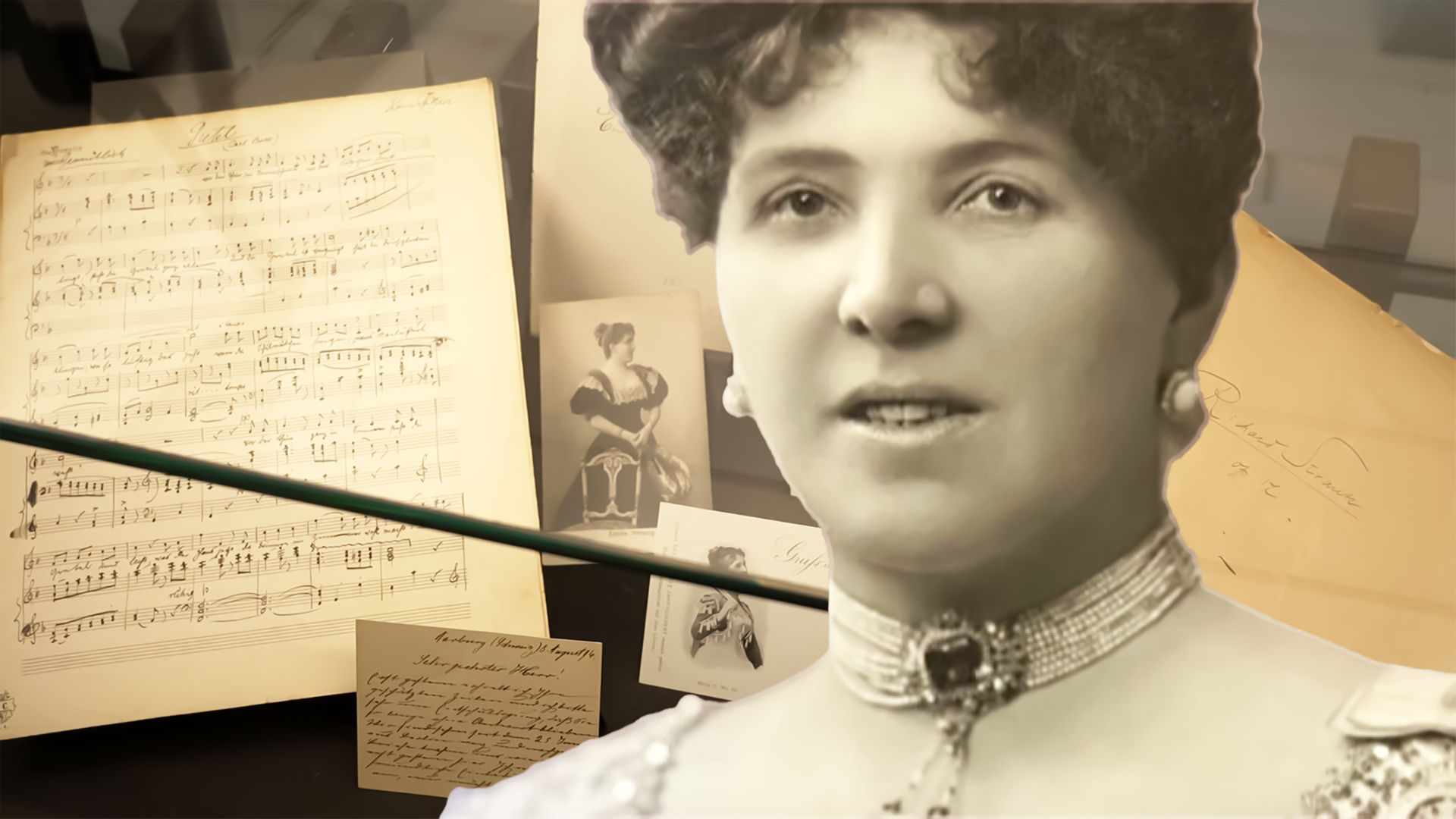 Das Bild zeigt ein Portrait einer Frau, umgeben von historischen Dokumenten, darunter Notenblätter und Fotografien. Einige Schriftstücke sind handgeschrieben, und es gibt eine Unterlage mit einer Unterschrift.