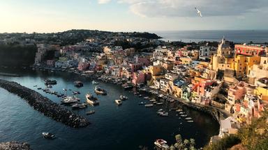 Blick auf die dicht bebaute Insel Procida, ringsum das Meer. 