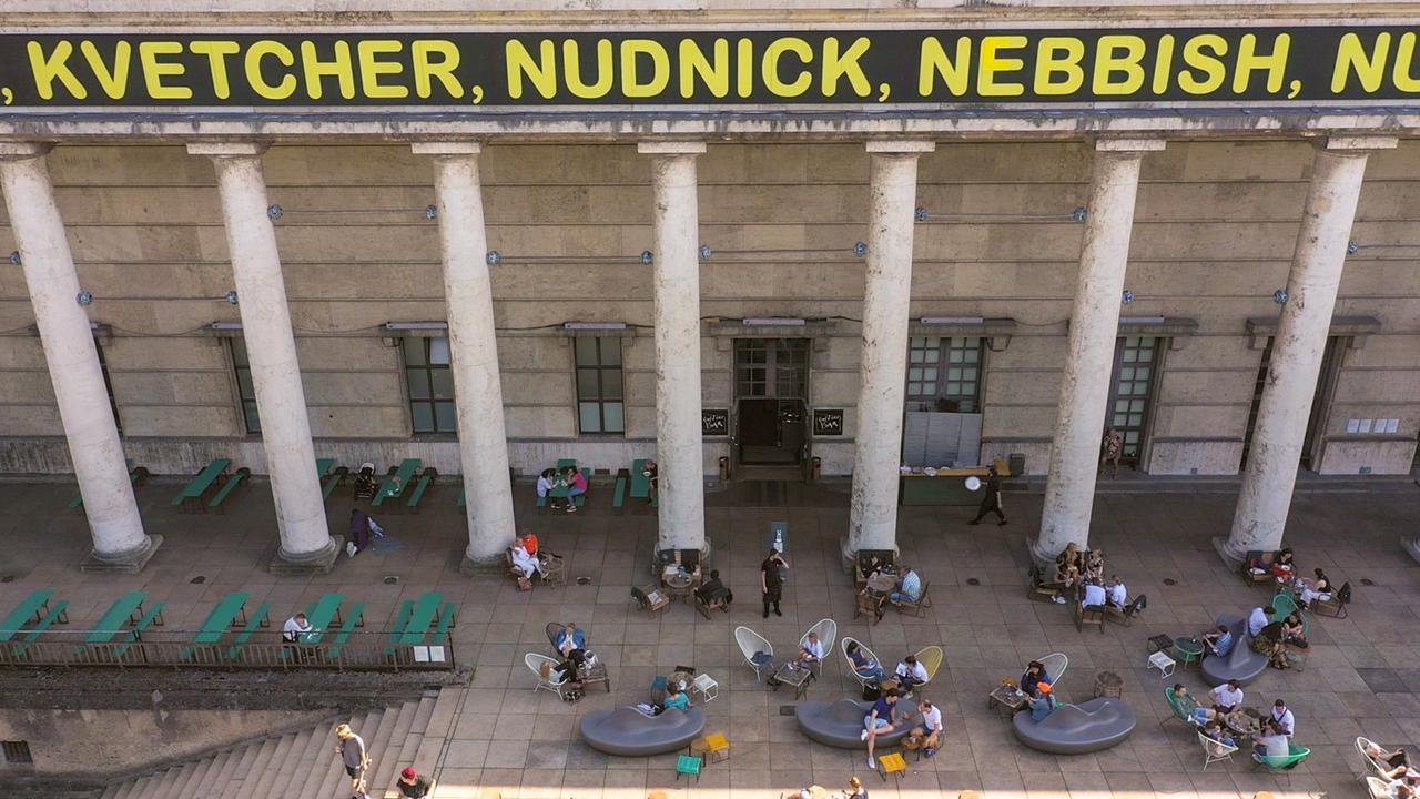 Säulenfassade mit gelber Schrift überzogen