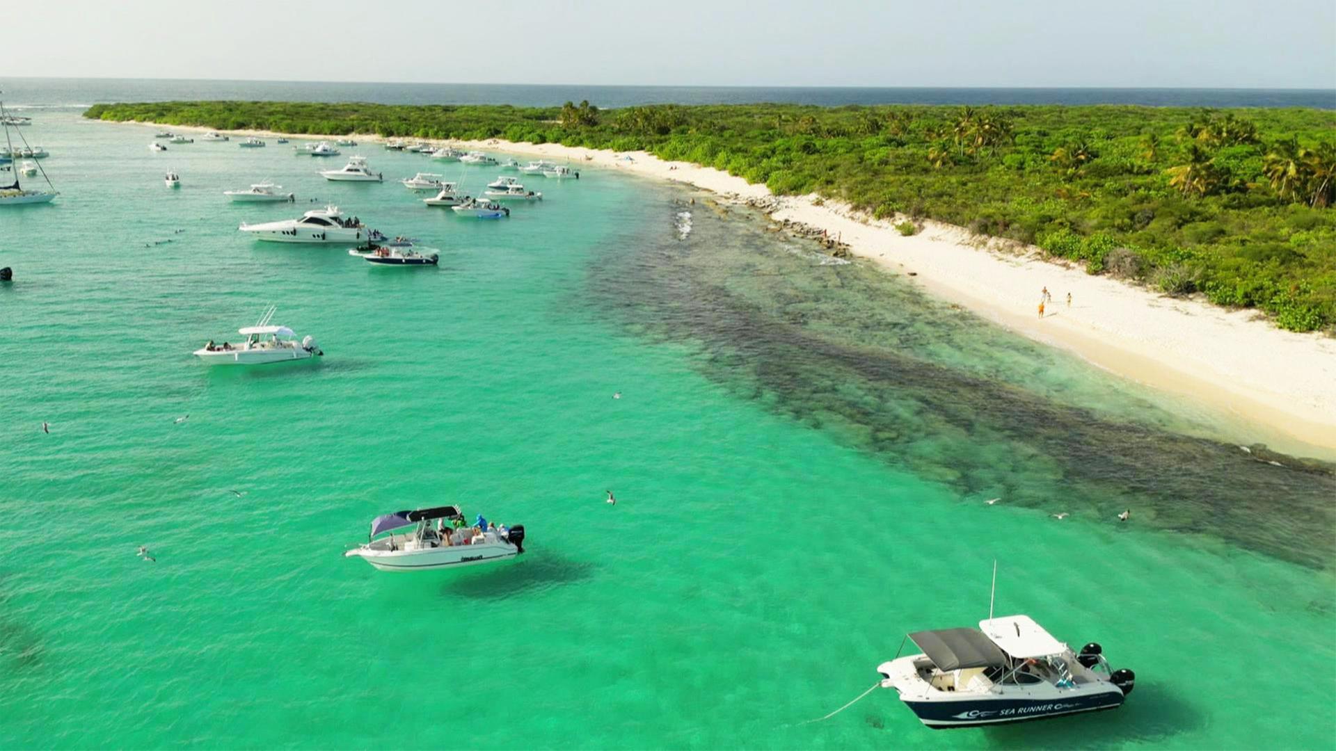 Boote liegen in einer Bucht in türkisfarbenem Wasser