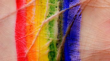 Handfläche bemalt mit den Regenbogenfarben