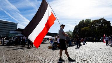 Mann läuft mit Flagge des deutschen Kaiserreichs über einen Platz