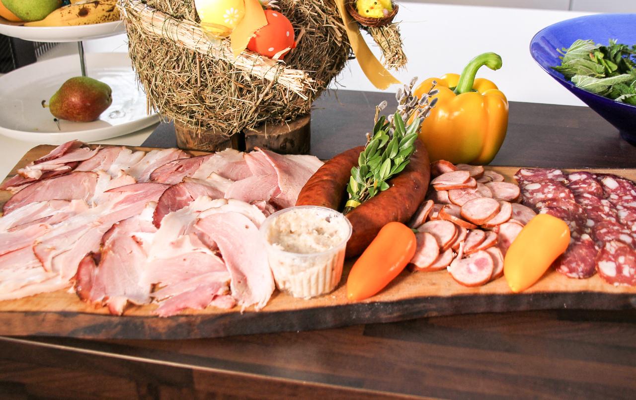 Holzbrett mit angerichtetem Schinken und Wurst