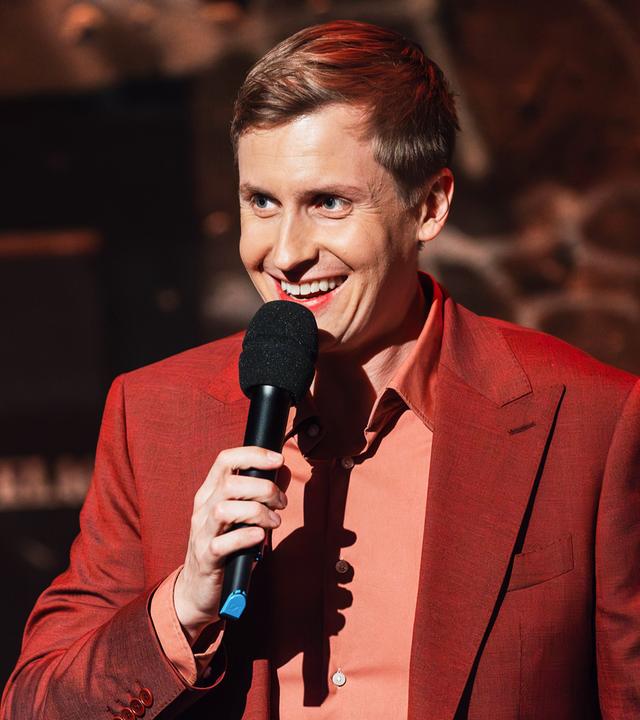 Lachender Moderator mit Mikrofon