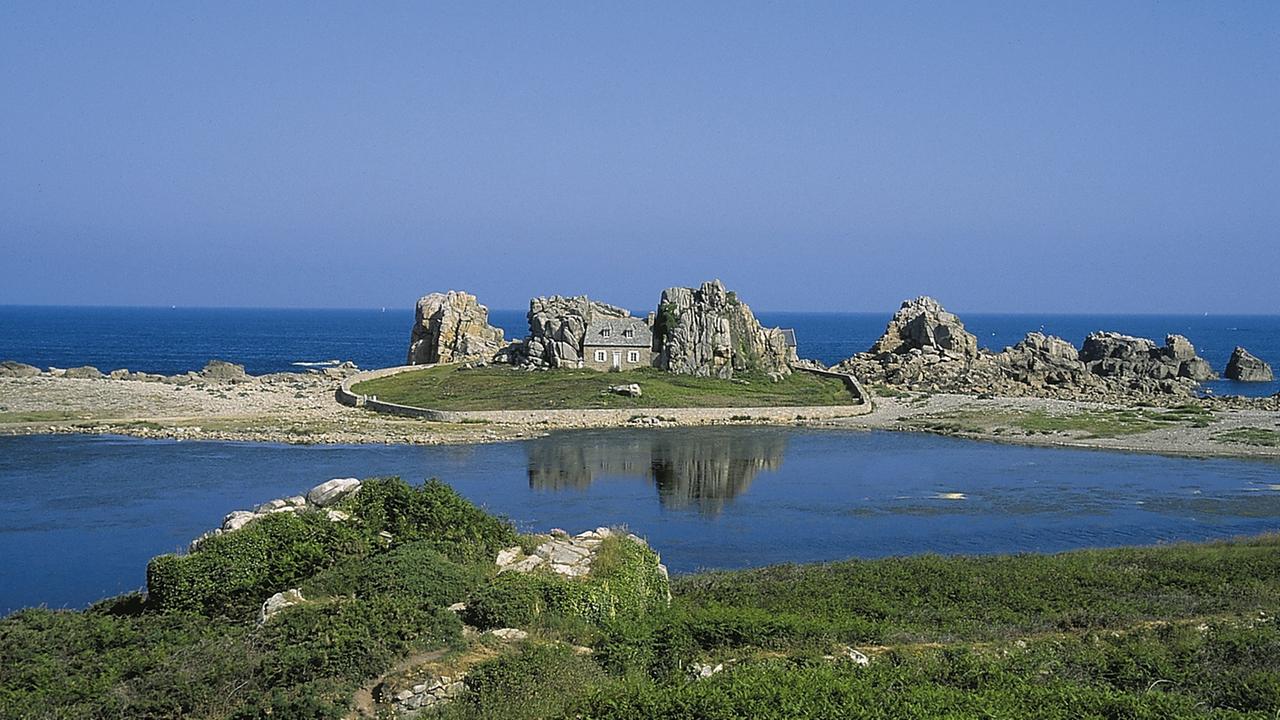 Küste in der Bretagne mit einem Haus zwischen Felsen